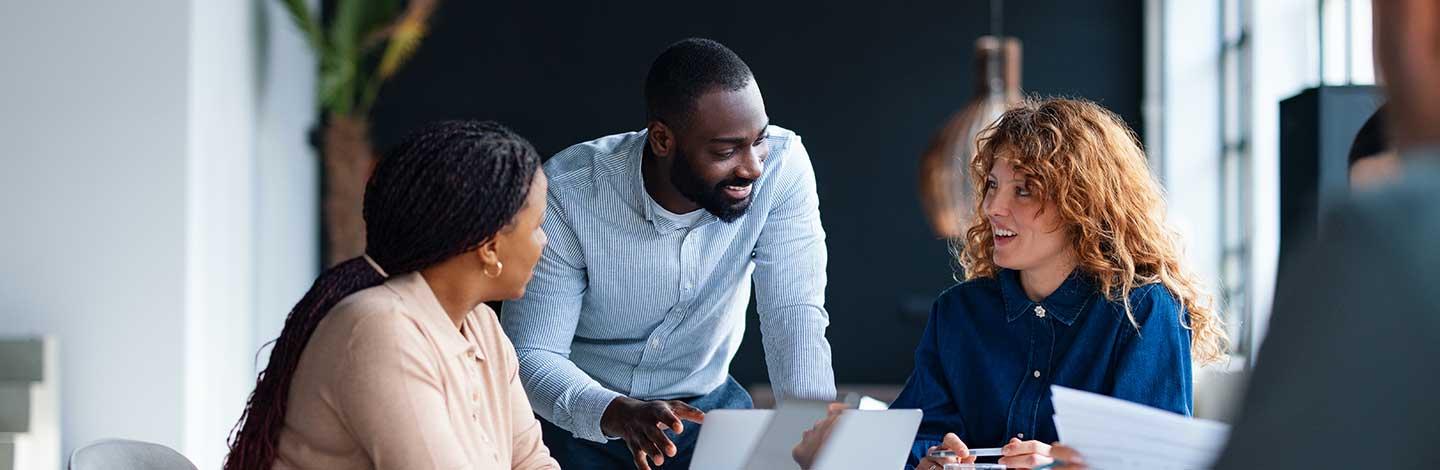 Procurement team working together and talking in office setting