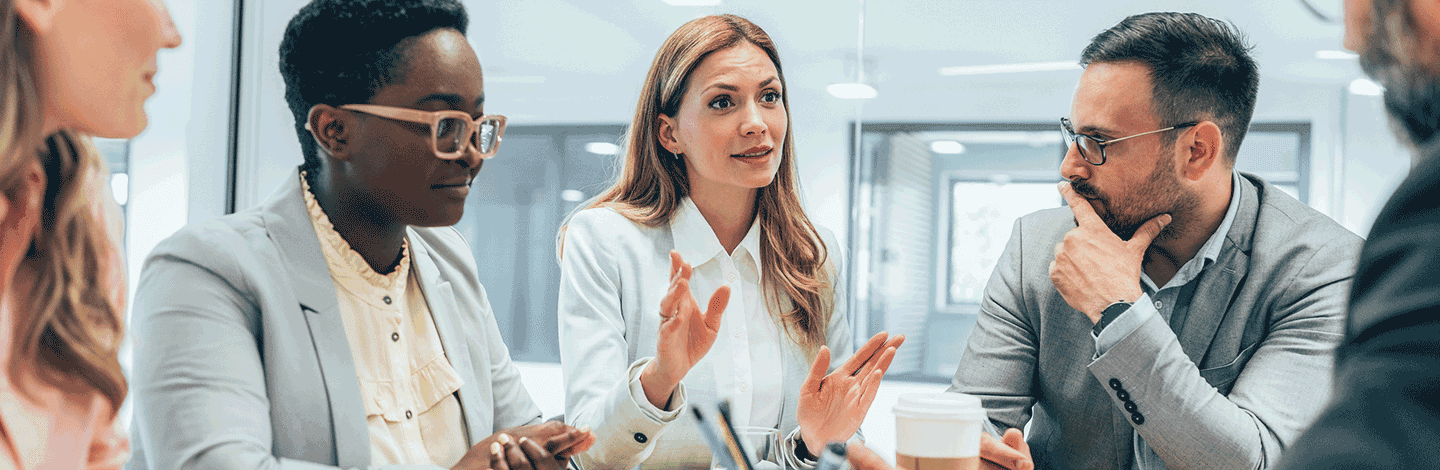 Five employees sitting in a meeting room